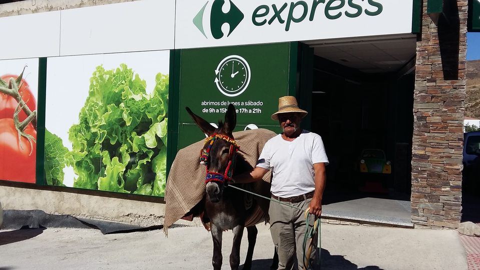 señor con un burro en la puerta del Carrefour express