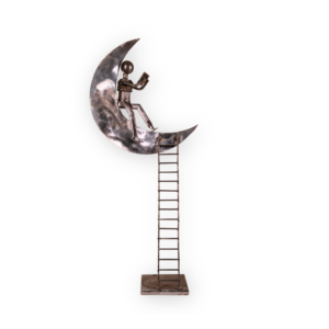 figura hombre leyendo en la luna sobre escaleras acero